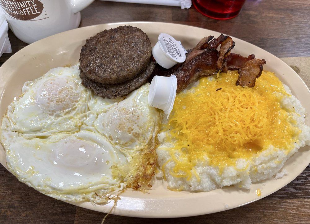 Eggs over easy, sausage patties, bacon and cheese grits
