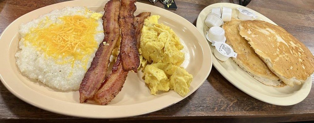 Hungry Man breakfast: bacon, scrambled eggs, cheese grits and a side of pancakes
