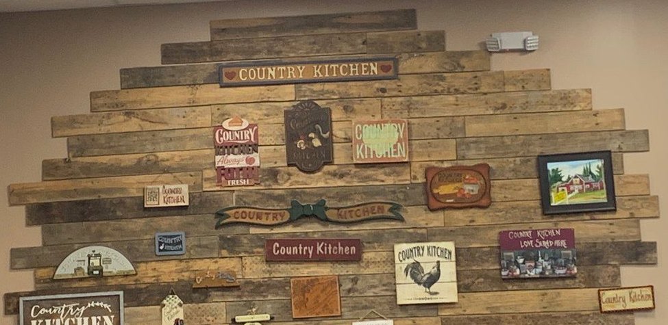 Reclaimed-wood wall covered in Country Kitchen signs